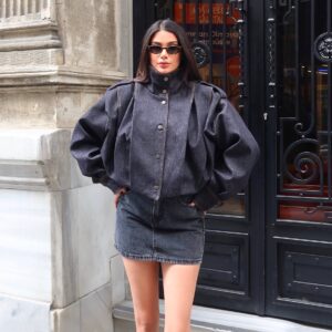 Model wears a dark charcoal denim jacket with balloon sleeves and a short matching skirt.