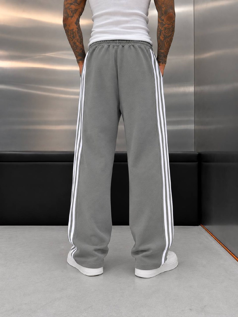 gray-بنطال-رياضي-خلف-9162-تجارة-جملة-تركيا عرض خلفي لبنطال رمادي واسع الساق مع خطوط بيضاء خارجية على الساقين وخصر مطاطي.