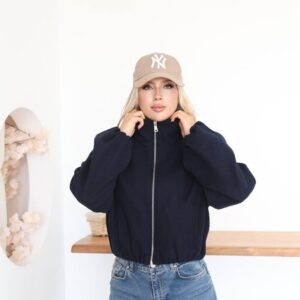 Front view of a navy cropped jacket with a silver center zipper, high collar, balloon sleeves, and vertical pockets.