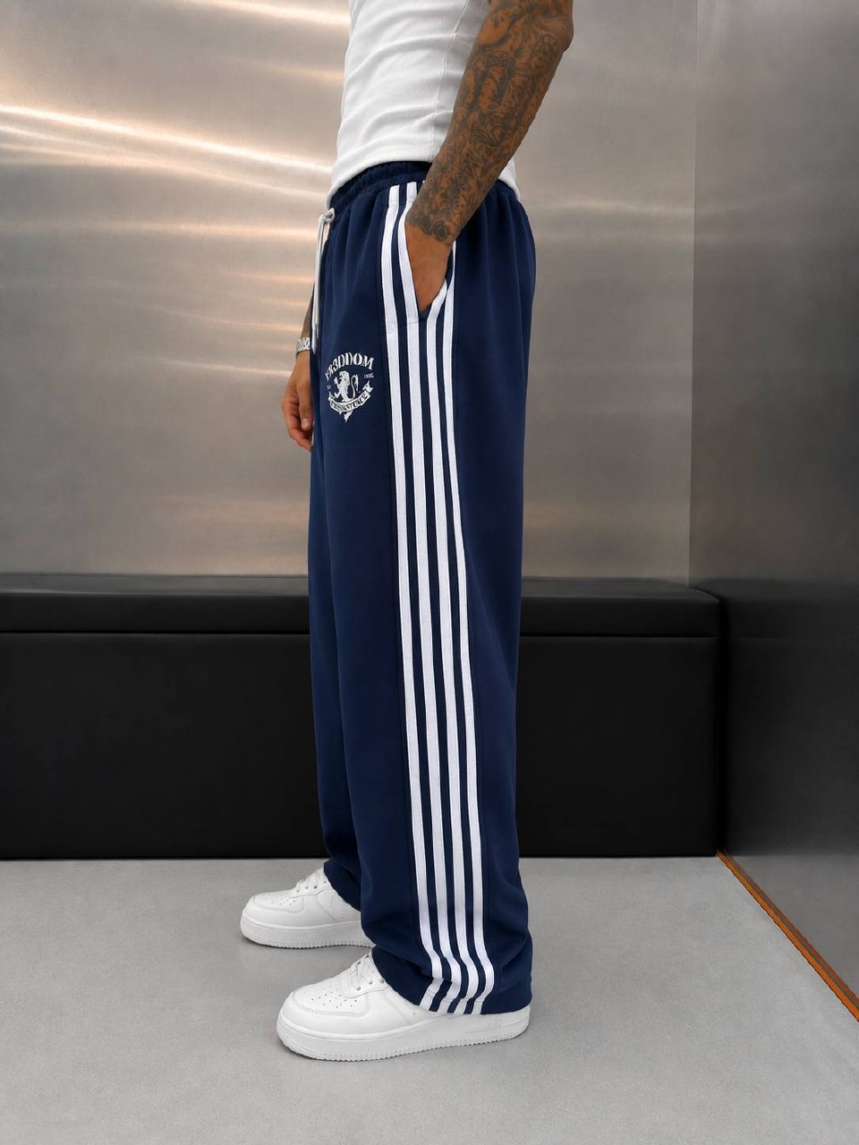 navy-بنطال-رياضي-جانب-6093-تجارة-جملة-تركيا عرض جانبي لبنطال أزرق داكن واسع الساق بثلاث خطوط بيضاء وجيب جانبي.
