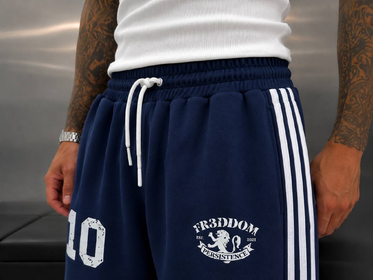 navy-بنطال-رياضي-خصر-8451-تجارة-جملة-تركيا لقطة مقربة لخصر بنطال أزرق داكن مع حزام مطاطي، ربطة شد بيضاء، جيب جانبي، ورسومات فخذ مطبوعة.
