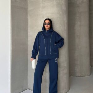 Full-length view of navy hoodie and wide-leg sweatpants with contrast piping, model wearing sunglasses and holding a cup. available for wholesale in Turkey.