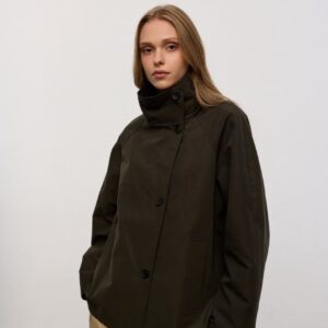 بورتريه استوديو لعارضة ترتدي olive-high-collar jacket بطراز أمامي مائل و جيوب جانبية عملية. متاح للشراء بالجملة من تركيا.