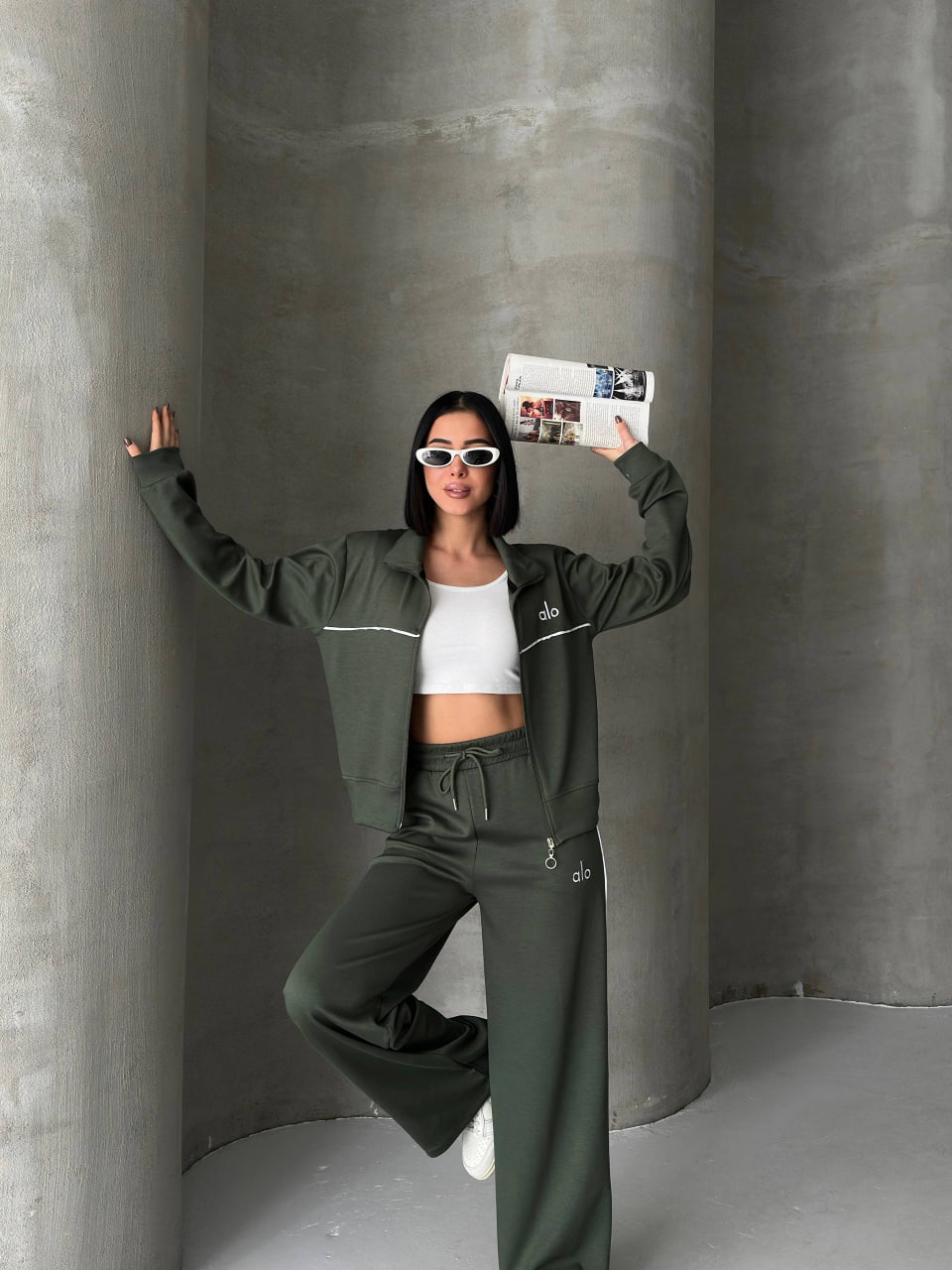 طقم-رياضي-olive-عرض-متناسق-7315 جاكيت زيتوني بسحاب وبنطال واسع مع خطوط بيضاء، تُرتدى فوق توب أبيض قصير - جملة تركيا