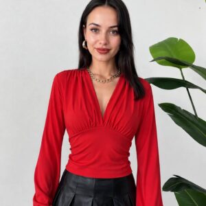 Front view of a red long-sleeve blouse with a deep V neckline, gathered waist, and wide waistband. available for wholesale in Turkey.