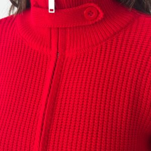 Close-up of red knitted turtleneck showing ribbed knit, zipper pull and button strap. available for wholesale in Turkey.