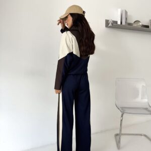 Rear view of the navy set showing a colorblocked jacket and cream and brown stripes along the pants.