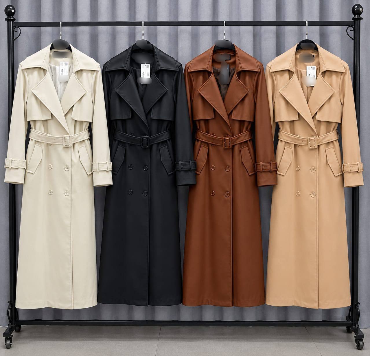 trenchcoat-farbpalette-8643-tuerkei-grosshandel Vier lange Trenchcoats in Elfenbein, Schwarz, Braun und Kamel hängen nebeneinander. Türkei-Großhandel erhältlich.