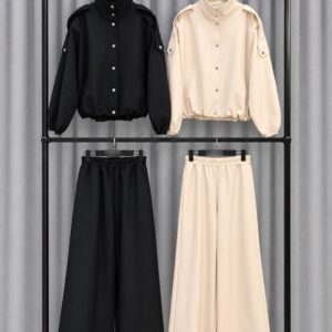 Cream and black outfit sets displayed on hangers, each with a button-front jacket and wide-leg trousers.