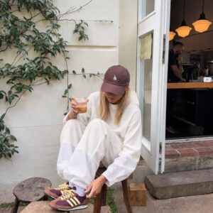 Sitzendes Model trägt weißes Sweatshirt und weite Hose mit strukturierten Saumabschnitten. Großhandel Türkei verfügbar - Türkei-Großhandel