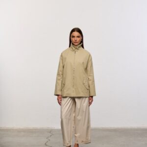 Full-length view of a beige zip jacket with flap pockets, paired with wide-leg trousers and flats.