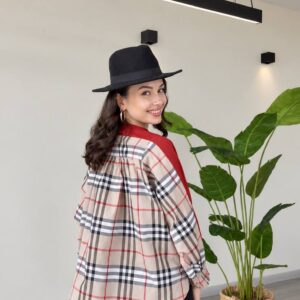 Back view of a loose beige plaid top with red accents, gathered yoke, and red shoulder panels. available for wholesale in Turkey.
