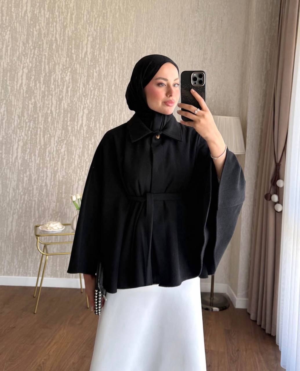 black-cape-coat-front-2956 Front view of a black cape-style coat with wide sleeves, a pointed collar, button closure, and waist tie.