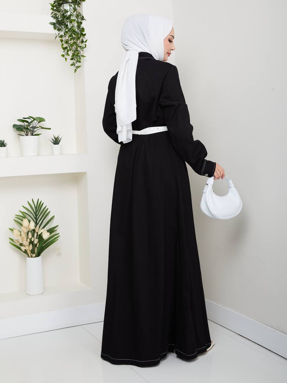 schwarz-denim-maxi-kleid-rueckansicht-3470-grosshandel-tuerkei Rückansicht eines schwarzen Maxikleids mit langen Ärmeln, weißem Taillengürtel und kontrastfarbiger Saumnaht – Großhandel Türkei verfügbar.