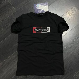 Flat-lay view of a black short-sleeve T-shirt with a crew neckline and rectangular red, white, and black chest patch. available for wholesale in Turkey.