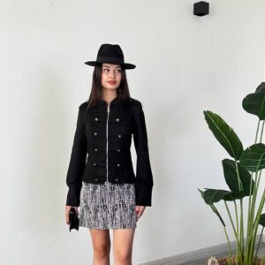 Full outfit featuring a black zip-front jacket with button trim and a black-and-white patterned mini skirt.