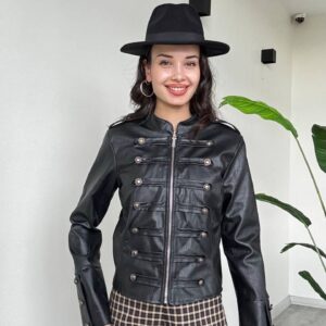 Front view of a black button-detailed jacket worn with wide-leg brown and cream plaid trousers.
