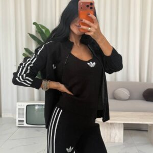 Open black zip jacket reveals a matching sleeveless top, with white stripes along the sleeves and pants.