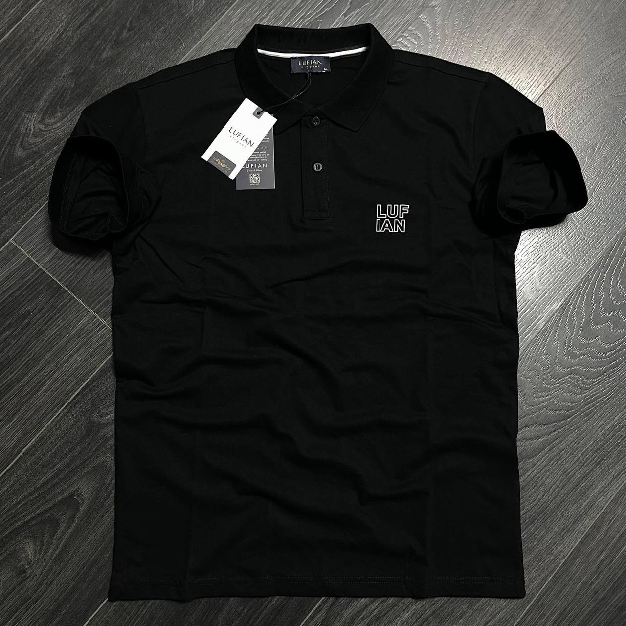 polo-negro-frente-5831-mayorista-turquia Polo negro de manga corta visto de frente, con cuello puntiagudo, botonadura de tres botones y letras en el pecho delineadas. Disponible para venta al por mayor en Turquía. - Mayorista Turquía