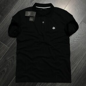 Polo negro de manga corta con tapeta de botones y una pequeña insignia blanca en el pecho, disponible al por mayor en Turquía - Mayorista Turquía
