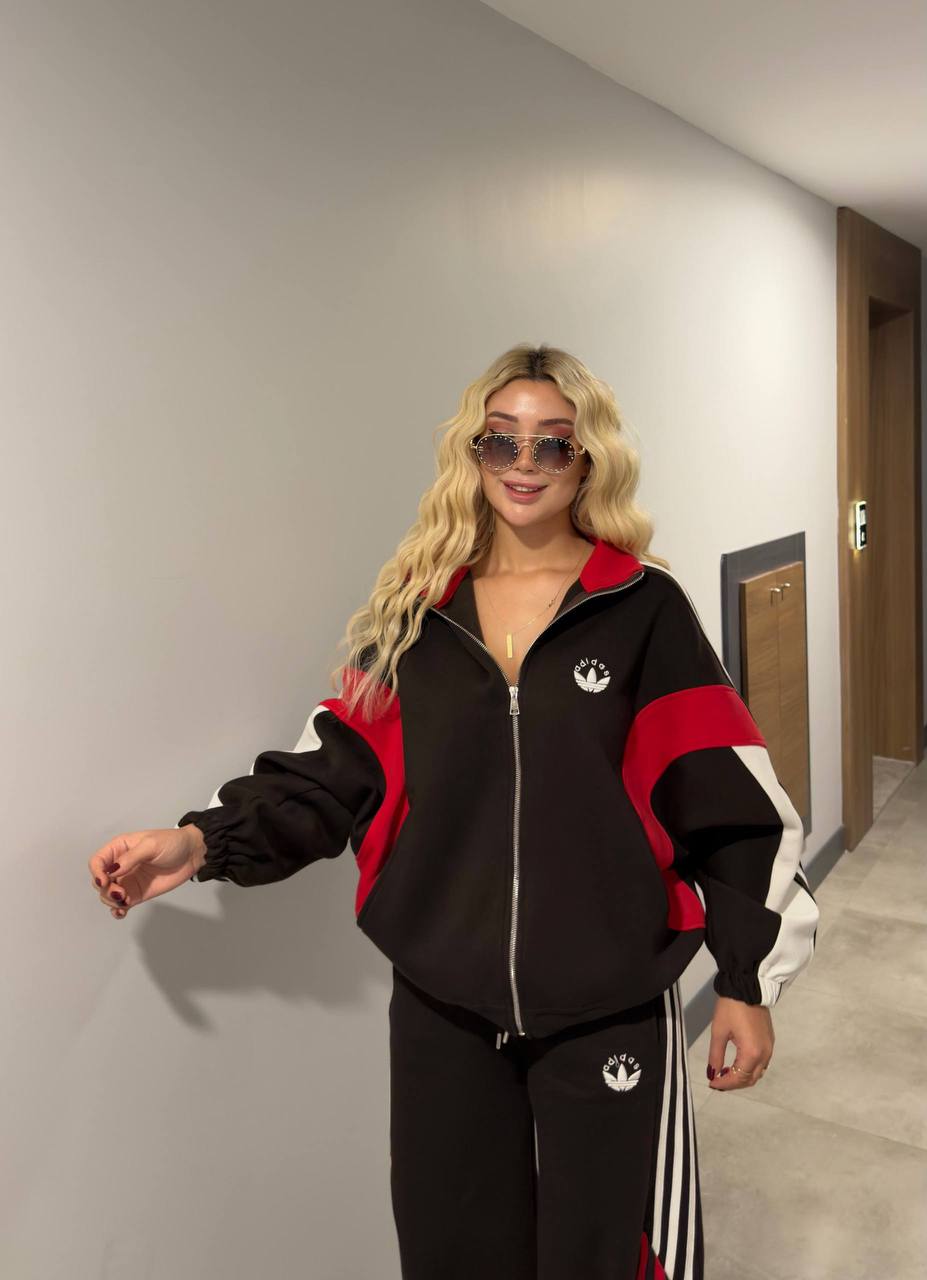 black-red-tracksuit-front-5831 Model wearing a black zip-up track jacket with red and white color-block sleeves and matching striped trousers. available for wholesale in Turkey.