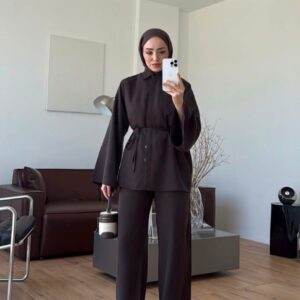 Model wearing a dark button-front top with a tie waist and matching wide-leg trousers.