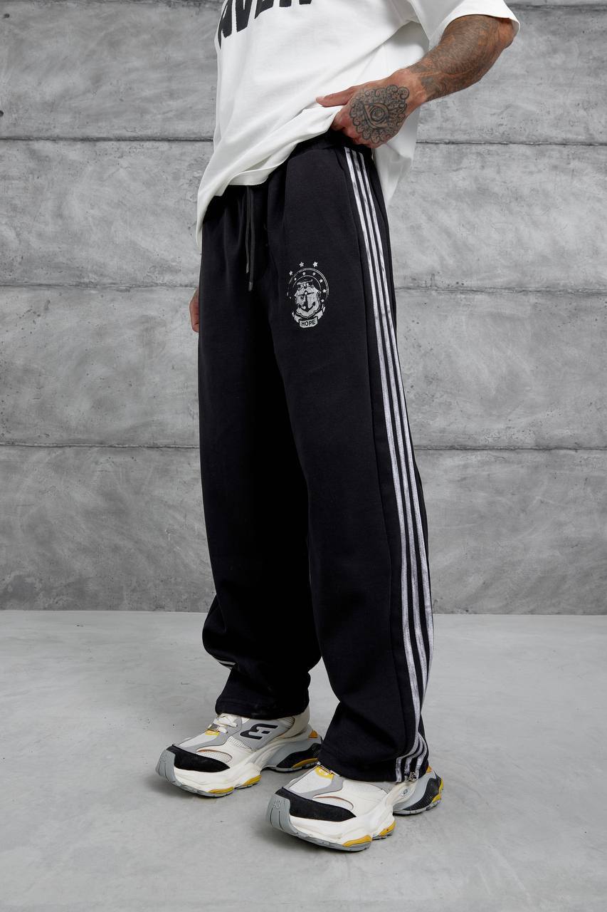 schwarz-doppelstrick-trackhose-seite-5902 – Großhandel Türkei Seitenansicht schwarzer Doppelstrick-Trackhose mit drei silbernen Streifen und kleinem Oberschenkel-Emblem - Großhandel Türkei