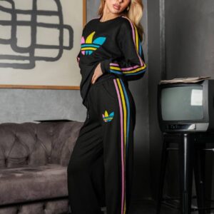 Full-length front view of a black sweatshirt and loose pants with colorful stripes down the sleeves and legs.