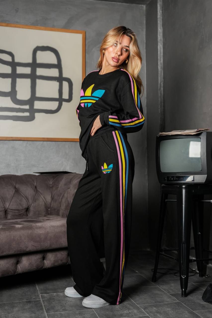 black-tracksuit-front-3470 Full-length front view of a black sweatshirt and loose pants with colorful stripes down the sleeves and legs.
