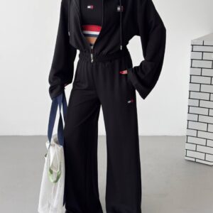 Black zip-front hoodie with drawstrings, matching wide-leg trousers, and a sleeveless top with striped accents.