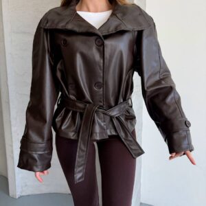 Vista cercana de una chaqueta marrón de aspecto cuero sintético que muestra su cuello doblado, botones de doble botonadura, cinturón y puños extragrandes. Disponible para mayorista en Turquía - Turquía mayorista.