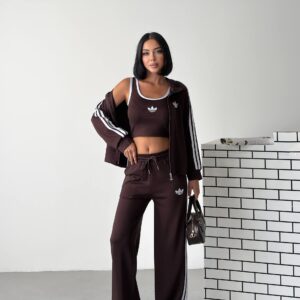 Model wearing a dark brown zip jacket and matching wide-leg pants with white stripes and an elastic drawstring waist.
