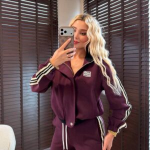 Front view of a burgundy track jacket with a raised collar, zip fastening, and striped sleeves.