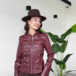 Three-quarter view of a burgundy jacket with a front zip, paired metallic buttons, shoulder tabs, and long sleeves.