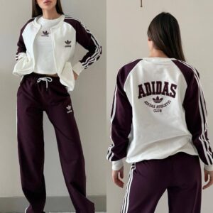 Burgundy wide-leg trousers and a white jacket with burgundy sleeves and striped trim.