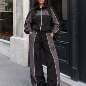 Vorderansicht einer Kapuzen-Reißverschlussjacke und weiten Hose mit anthrazitfarbenen Paneelen und weißen Paspeln. - Türkei-Großhandel