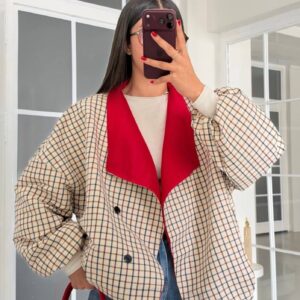 Front view of a beige checked jacket with red lapels, black buttons, and oversized sleeves, styled with jeans. available for wholesale in Turkey.