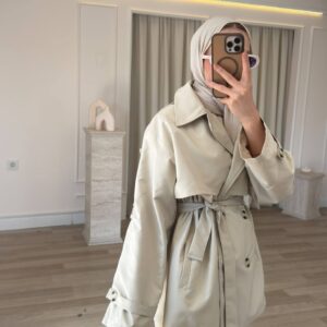 Cream belted trench coat shown from the front, with wide lapels, button closure, and cuff straps. available for wholesale in Turkey.