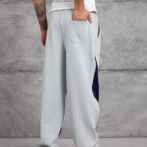 Rückansicht der hellgrauen, weiten Jogginghose mit eingelegter Gesäßtasche und marineblauen Akzenten an den äußeren Beinen. - Türkei Großhandel