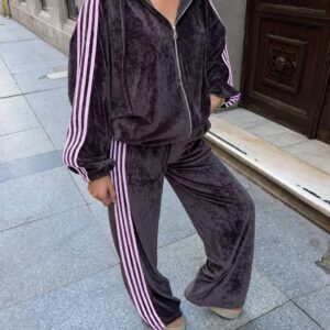 Nahaufnahme einer graphitgrauen Samt-Kapuzenjacke mit silbernem Reißverschluss und rosa Ärmel-Streifen, dazu passende Hose. turkei-grosshandel