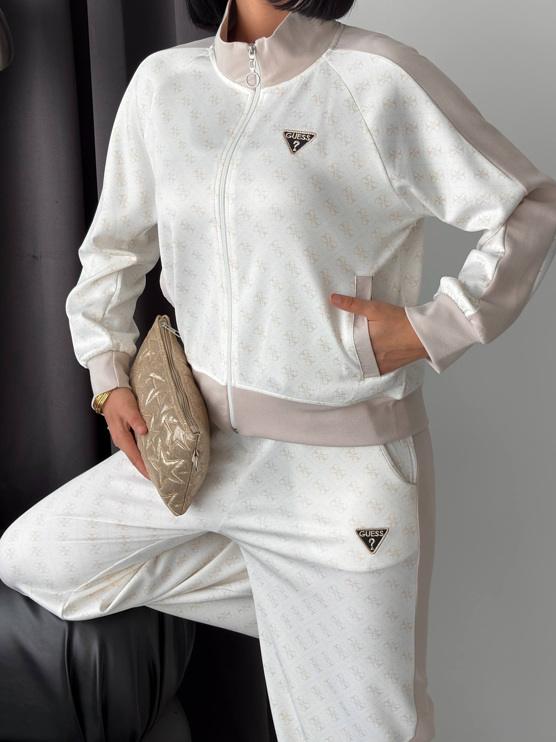 Elfenbeinfarbene Damen-Trainingsanzug-Jacke – Detail – Großhandel Türkei Nahaufnahme einer elfenbeinfarbenen Reißverschlussjacke mit dezentes Muster, taupe Raglanärmel-Paneele und hohem Kragen. Großhandel Türkei