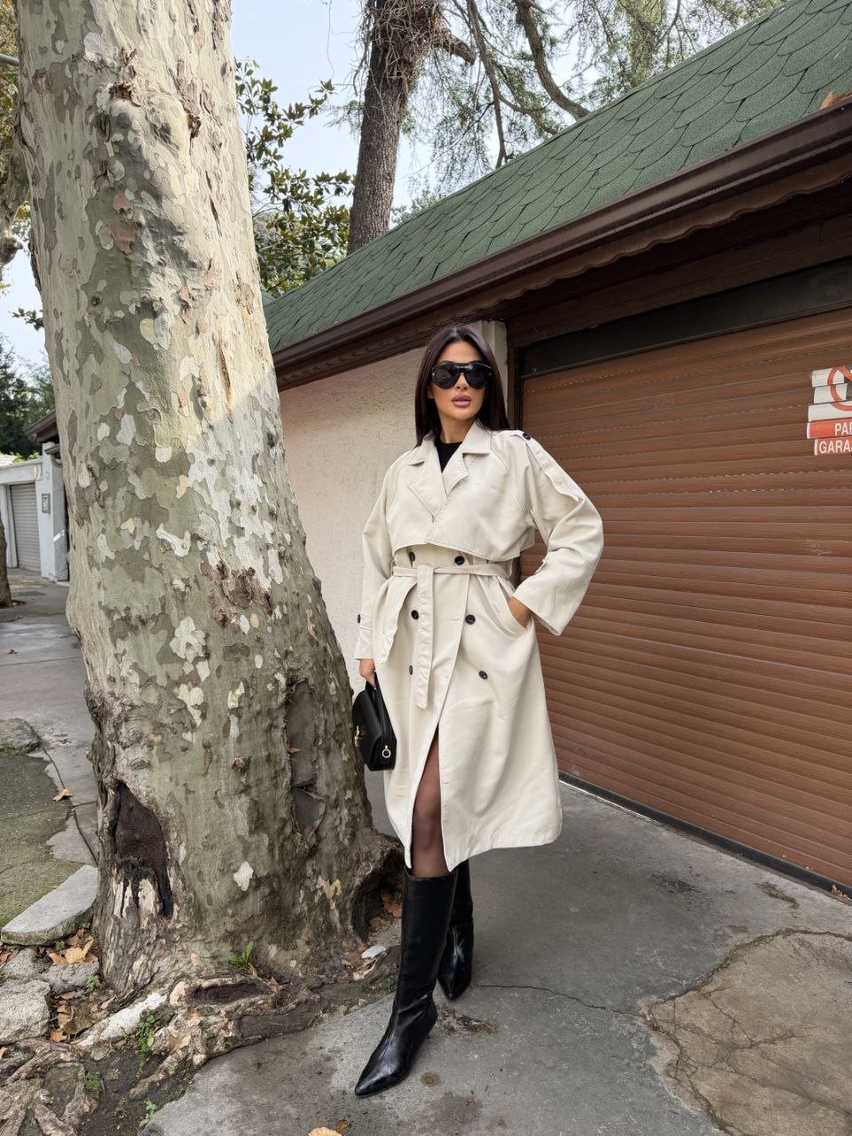 ivory-trench-full-length-7315 Full-length ivory trench coat with double-breasted buttons, broad lapels, a waist belt, and cuff tabs.
