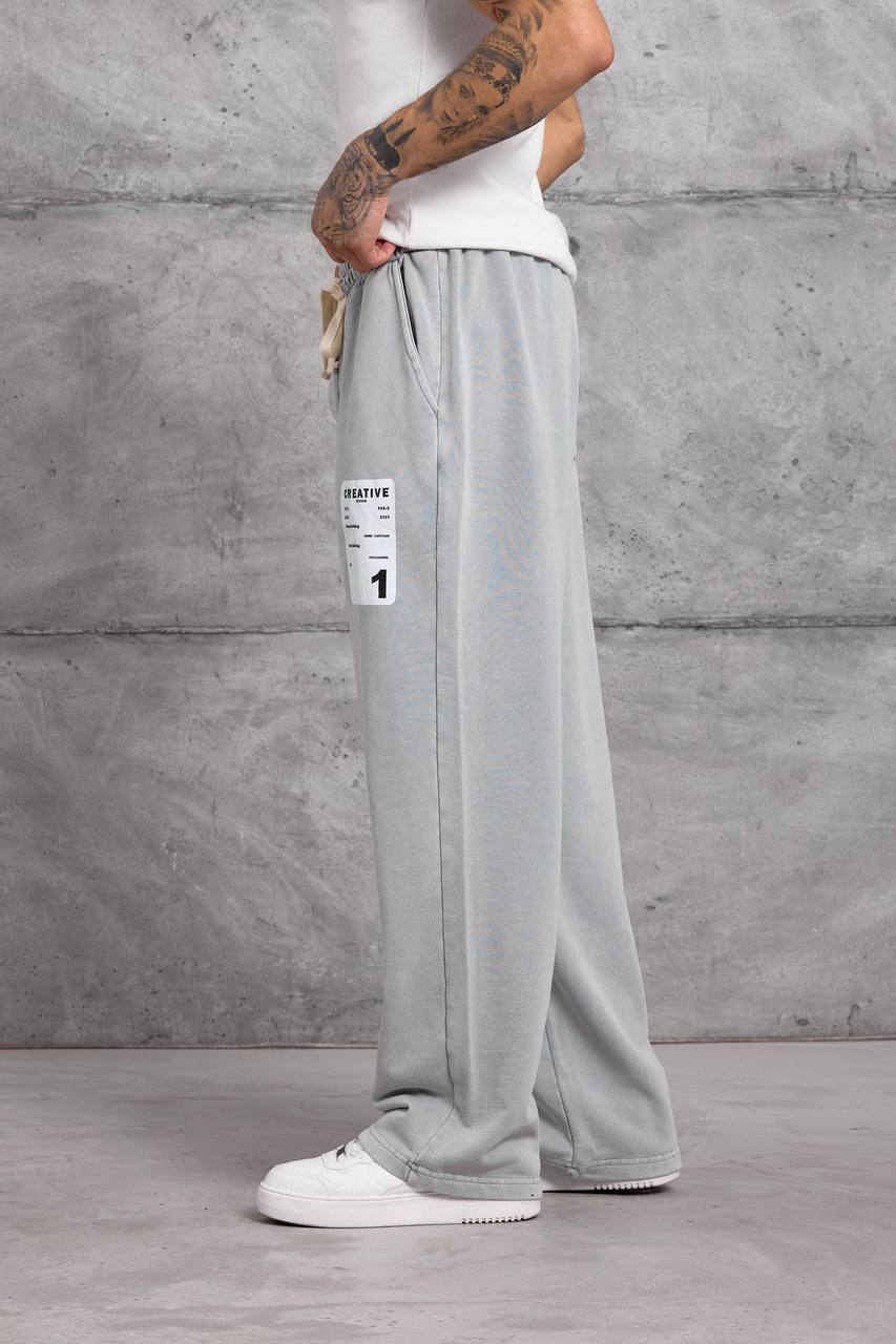 light-gray-wide-leg-sweatpants-side-3619 Side view of light gray wide-leg sweatpants with a cream drawstring and white rectangular thigh patch.