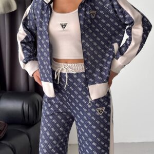 Close view of a navy zip-front jacket with repeating pale motifs, cream sleeves, ribbed cuffs, and a stand collar.