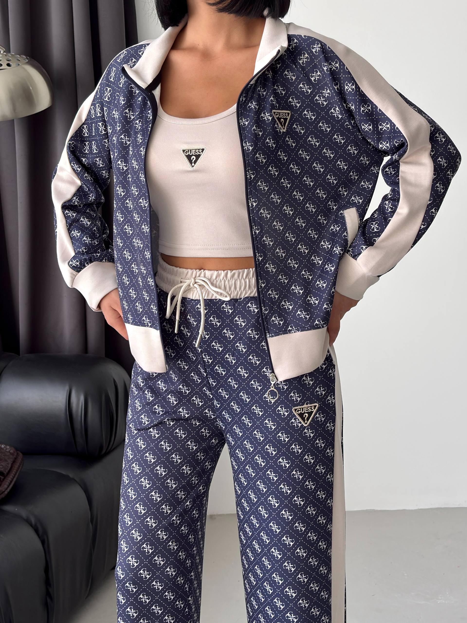 Marineblaue Jacke mit Muster-Detail – Großhandel Türkei Nahaufnahme einer marineblauen Reißverschlussjacke mit wiederkehrenden hellen Motiven, cremefarbige Ärmel, gerippte Bündchen und Stehkragen. Großhandel Türkei