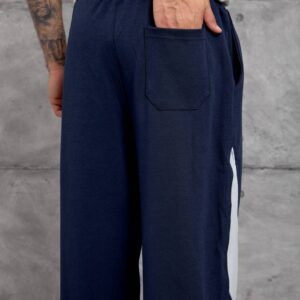 Rückansicht der marineblauen Jogginghose mit einer gesteppten Gesäßtasche und einem Blick auf das weiße Seitenpaneel. - Türkei Großhandel