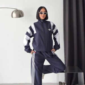 Full view of a navy zip-front jacket and loose trousers, accented with white shoulder panels and side stripes.