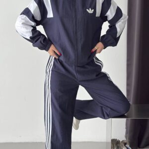 Navy zip-up jacket with a high collar, white sleeve panels, and matching wide-leg trousers with white side stripes. available for wholesale in Turkey.
