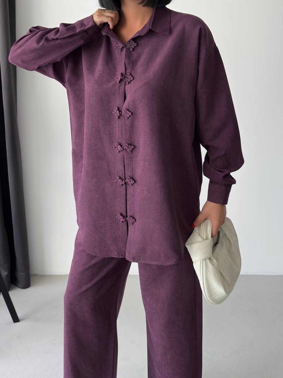 pflaumen-shirt-verschluss-detail-4068 – Großhandel Türkei Nahaufnahme pflaumenfarbener Bluse mit Kragen und Stoff-Froschverschlüssen sowie passender Hose. Großhandel Türkei erhältlich.