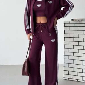 Front view of a plum tracksuit with a zip jacket, cropped tank, drawstring pants, and white side stripes. available for wholesale in Turkey.